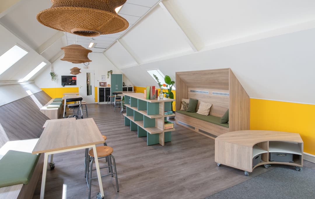 Op de afbeelding zie je een kinderopvang met boekenkasten en leeshuis.