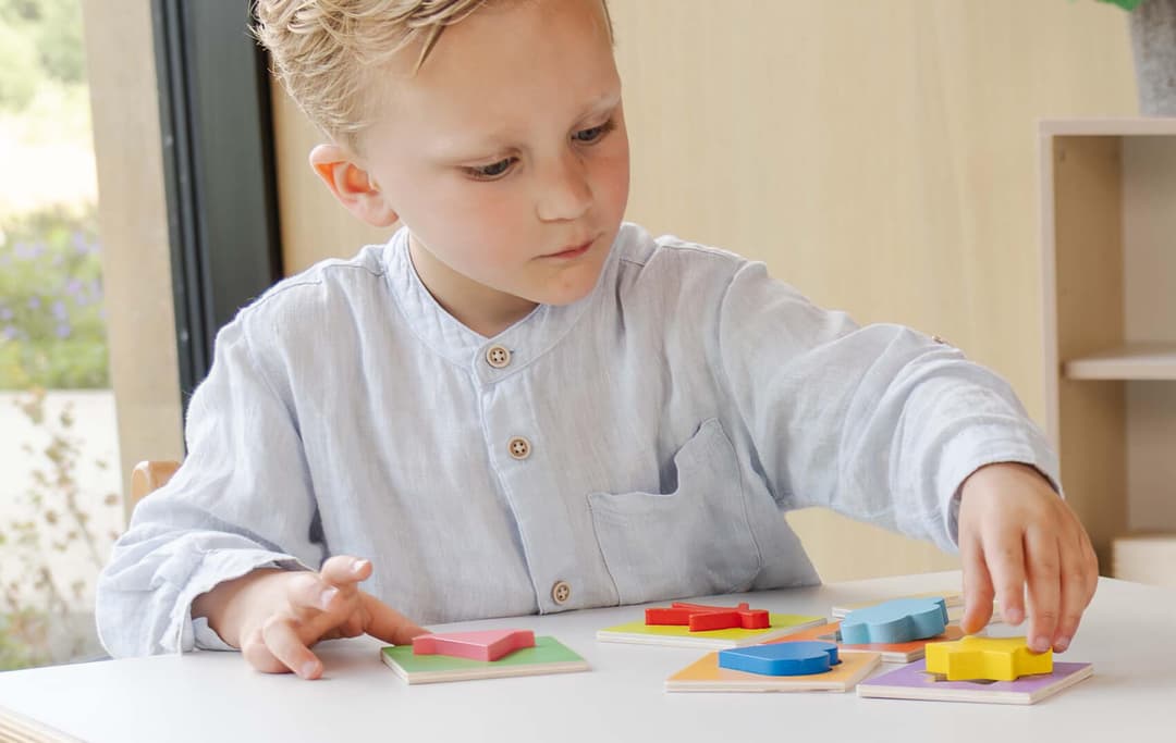 Op de afbeelding speelt een jongetje met educo ontwikkelingsmaterialen.