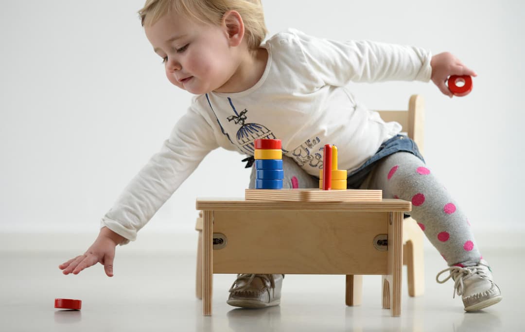 De peuter op de afbeelding grijpt naar een van de gevallen materialen van nienhuis.