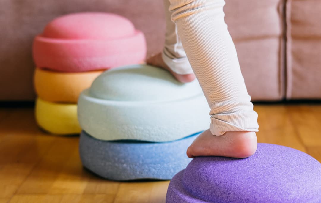 Op de afbeelding zie je een kind dat stapt op stapelstenen.