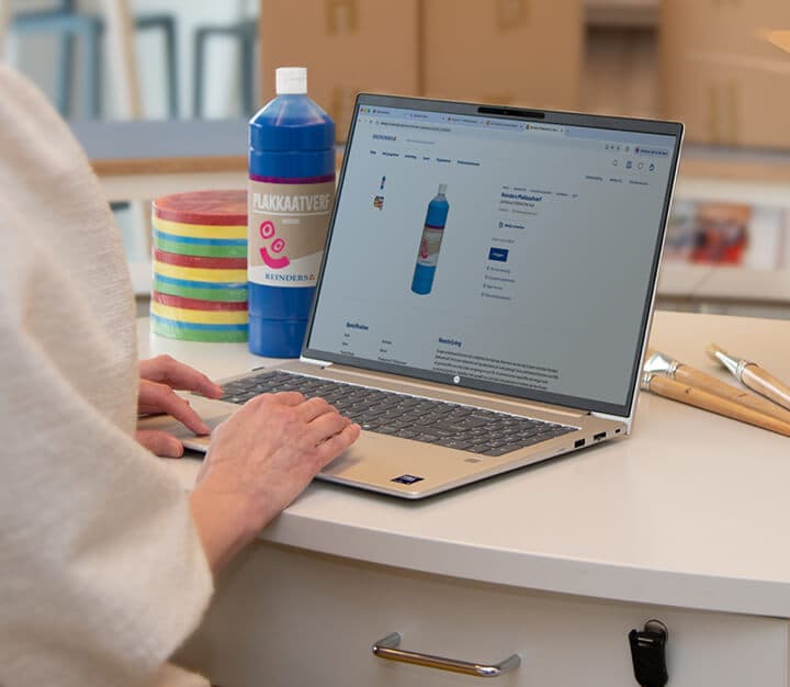 Medewerker zit achter de laptop op de website van reinders.