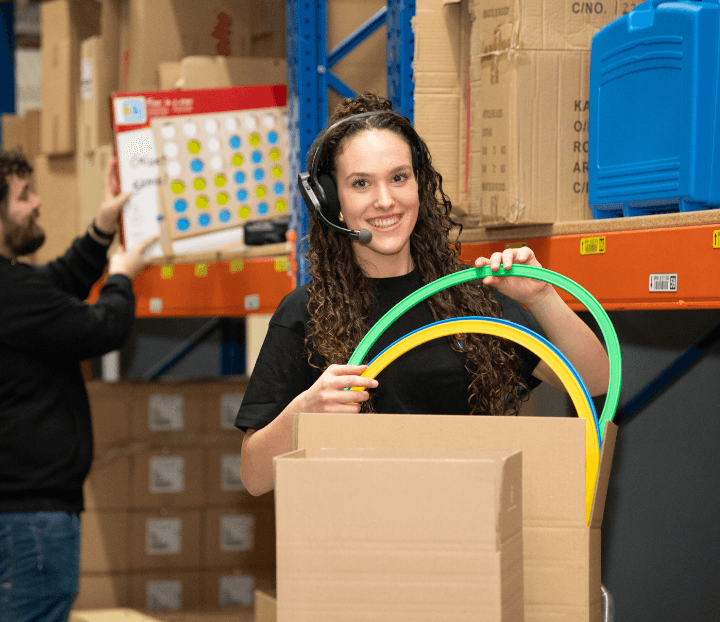 Logistiek medewerker doet artikelen in een doos.