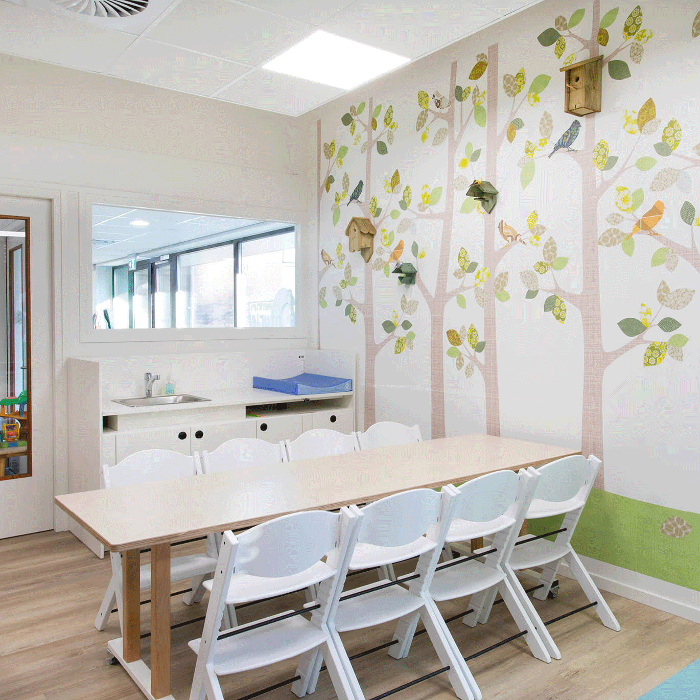 OP de afbeelding zie je een groepstafel met stoelen er omheen