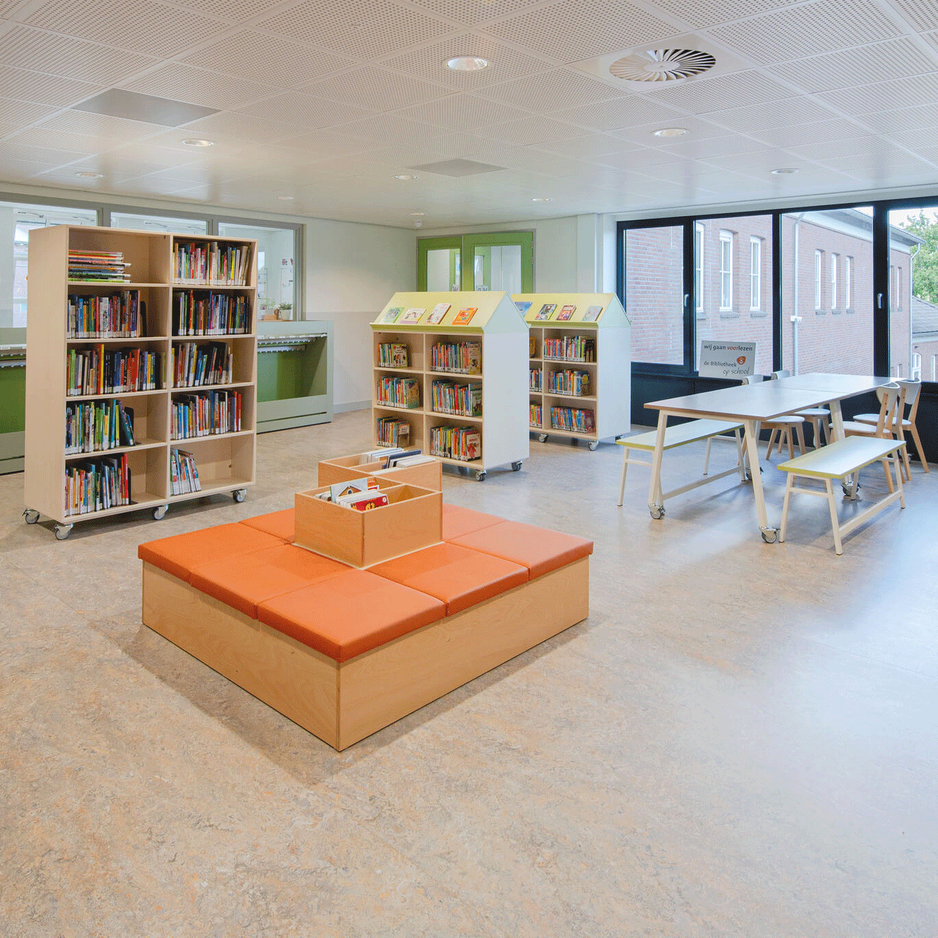 op de afbeelding zie je een bibliotheekruimte in een school met boekenkasthuisjes.