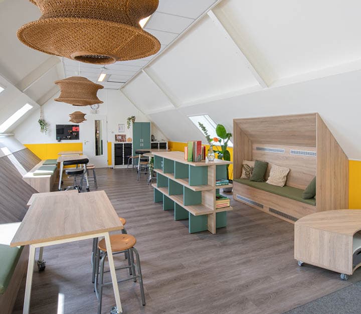 Op de afbeelding zie je een ruimte met lees bank en boekenkast.