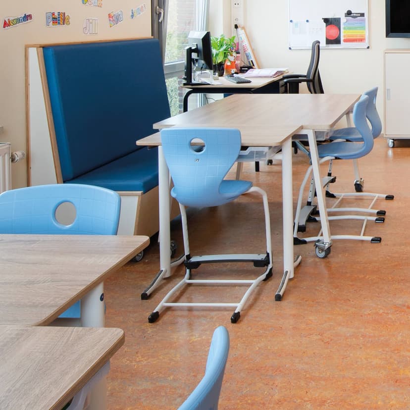 Op de afbeelding zie je tafels met blauwe stoelen en weinig opbergruimte.