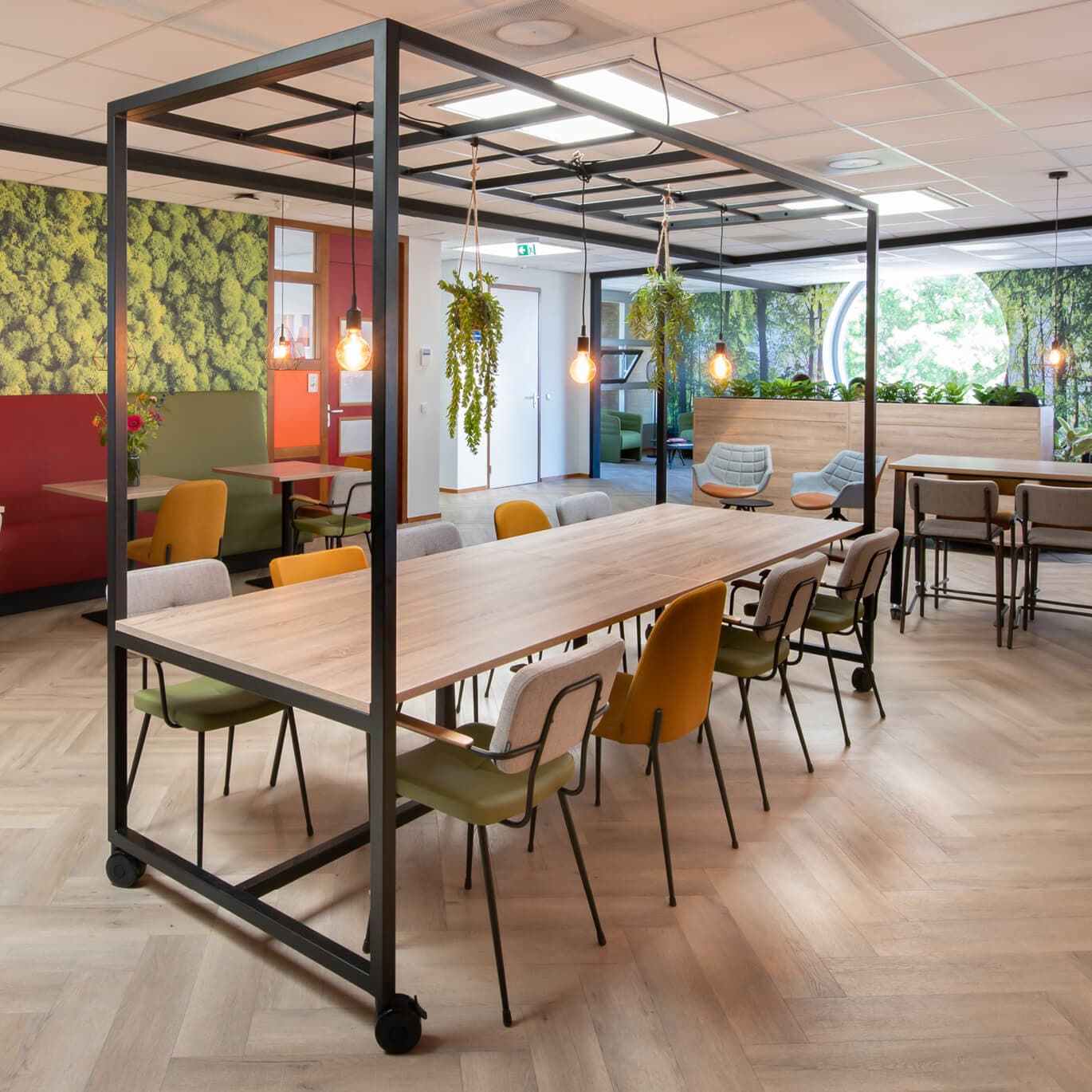 Op de afbeelding zie je tafels op zwenkwielen in een groene omgeving.